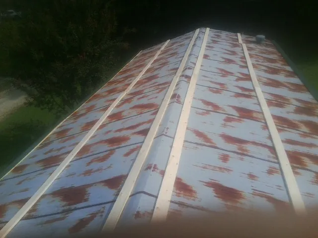 Rusted metal roof panels with new wood purlins before replacement — Storm Damage Roof Repair in Van Vleck by Roofing Brothers