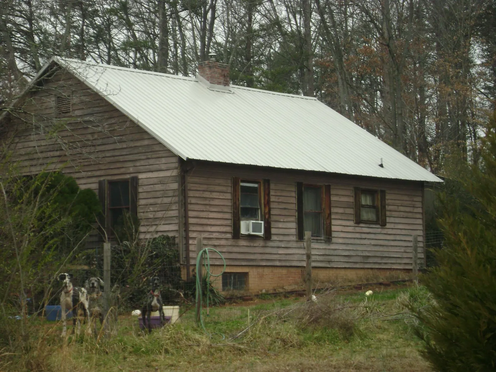 White metal roof on an old wood sided farmhouse, from a Metal Roof Installation job in Van Vleck